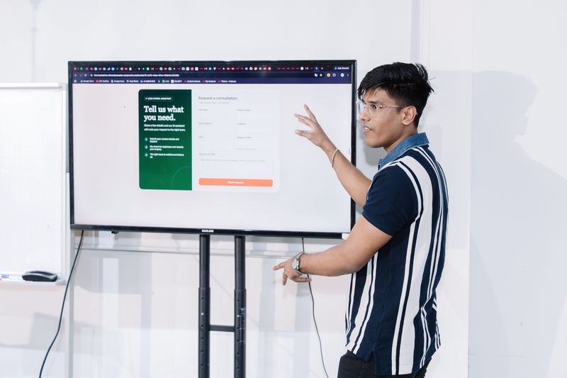 Gesturing at a screen showing a consultation intake form