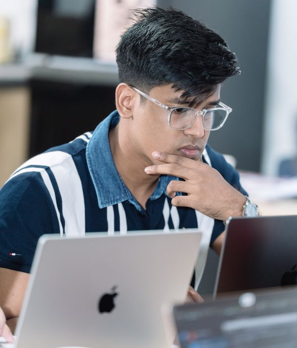 Deepankar at a laptop, hand on chin, thinking through a problem
