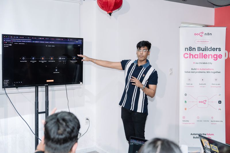 Deepankar pointing at an n8n workflow on screen beside the n8n Builders Challenge banner