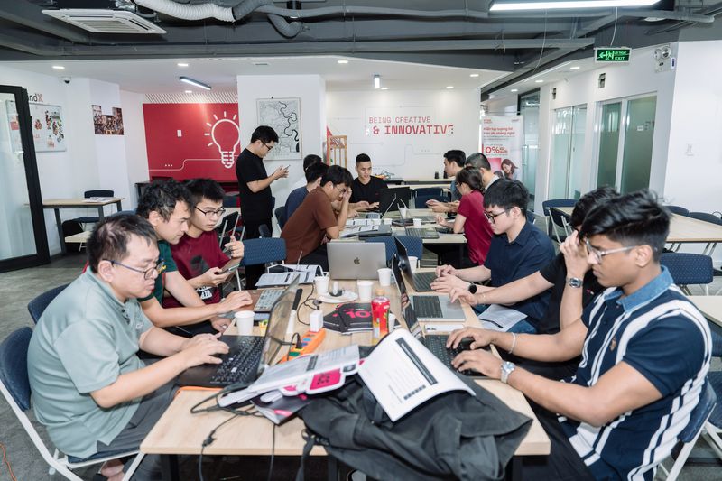 Wide view of the busy build room, Deepankar typing at the right